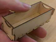 photo of plywood box, about 3" long, held in hand